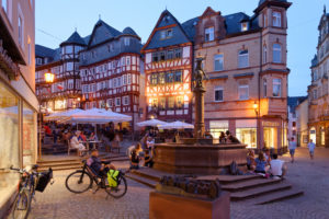 Fountain at the market square with half-timbered houses in the evening light, Marburg, Hesse, Germany Fountain at the market square with half-timbered houses in the evening light, Marburg, Hesse, Germany